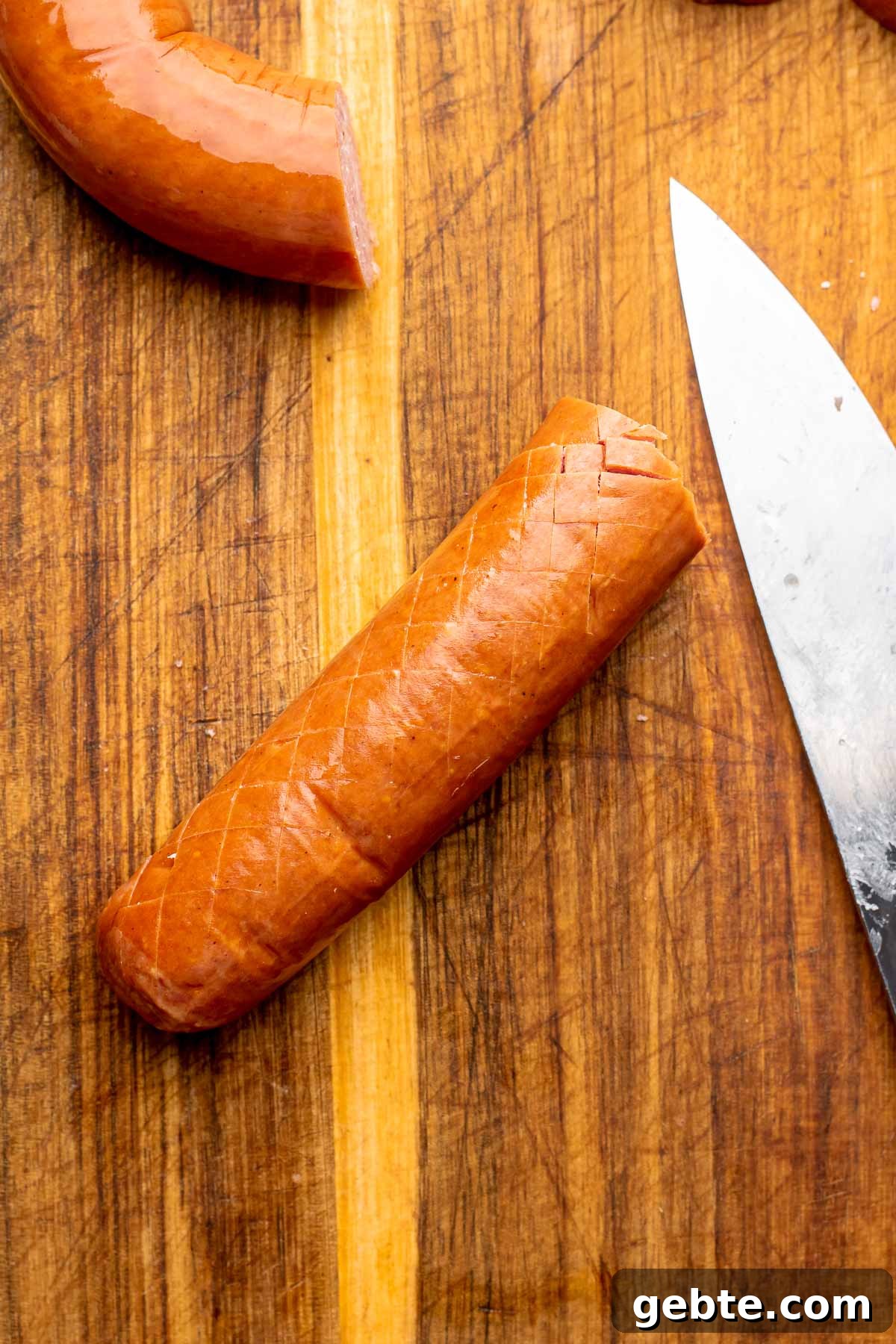 Sweet and Spicy Kielbasa Bites — 2-Ingredient Party Appetizer 3 A cross hatched piece of kielbasa on a cutting board.