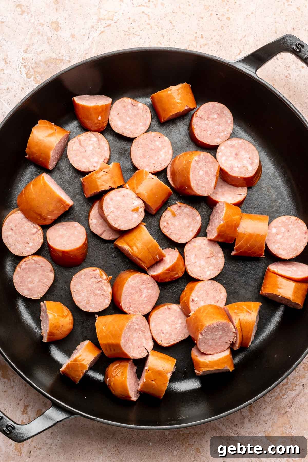 Sweet and Spicy Kielbasa Bites — 2-Ingredient Party Appetizer 4 Cut pieces of kielbasa in a frying pan.