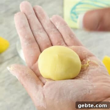 Lemon Cake Truffles: Zesty Bite-Sized Dessert Recipe 7 Mixture being formed into small balls with hands.