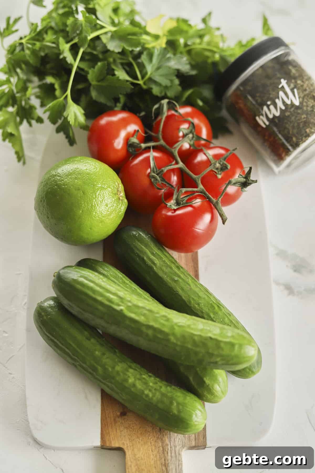 cucumber, tomato, lime, cilantro, and mint to make tomato and cucumber salad