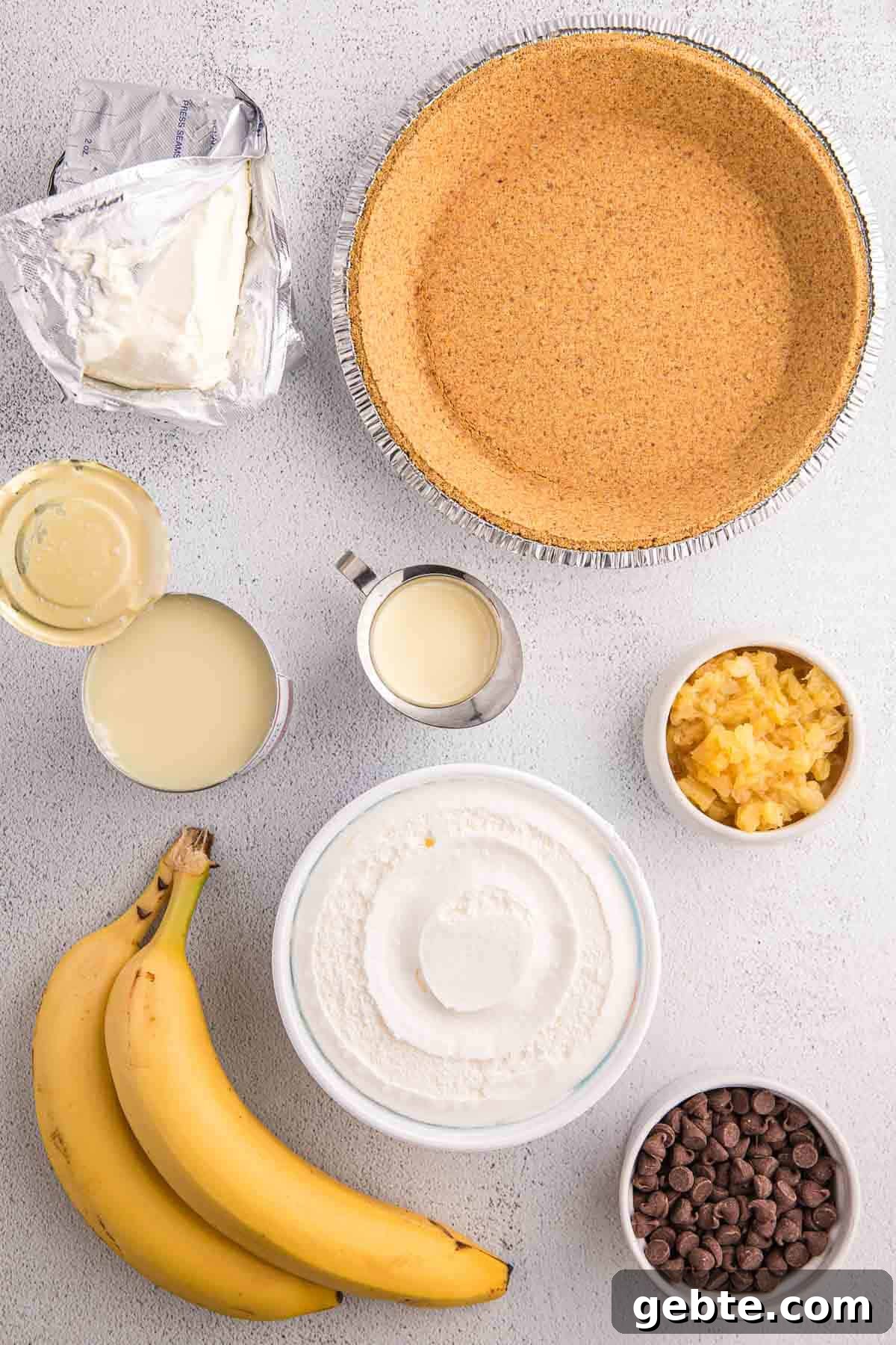 Ingredients for no bake banana split pie including bananas, cream cheese, crushed pineapple, sweetened condensed milk, chocolate chips, and a graham cracker crust.