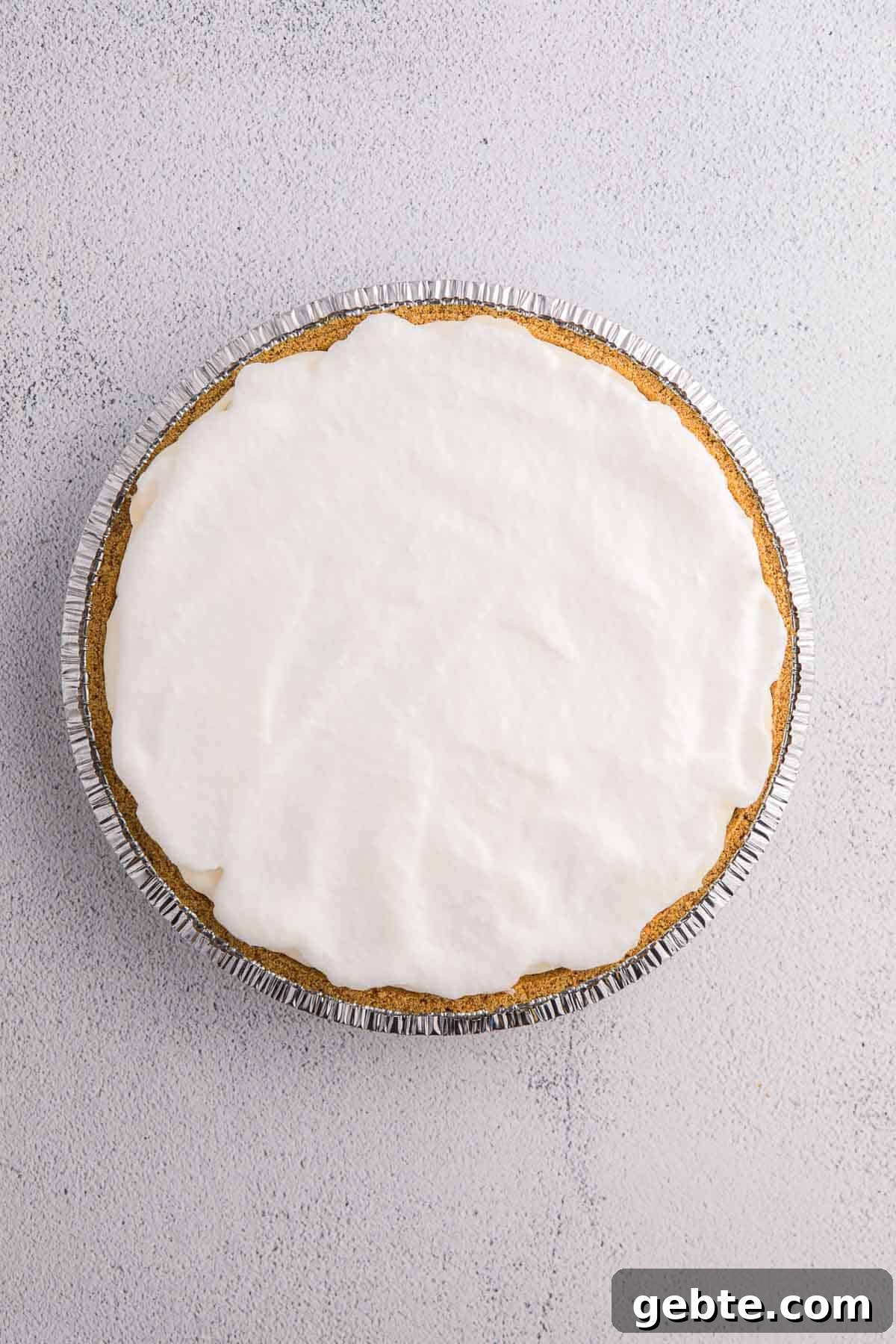 Layer of whipped topping spread over pie filling in a graham cracker crust.
