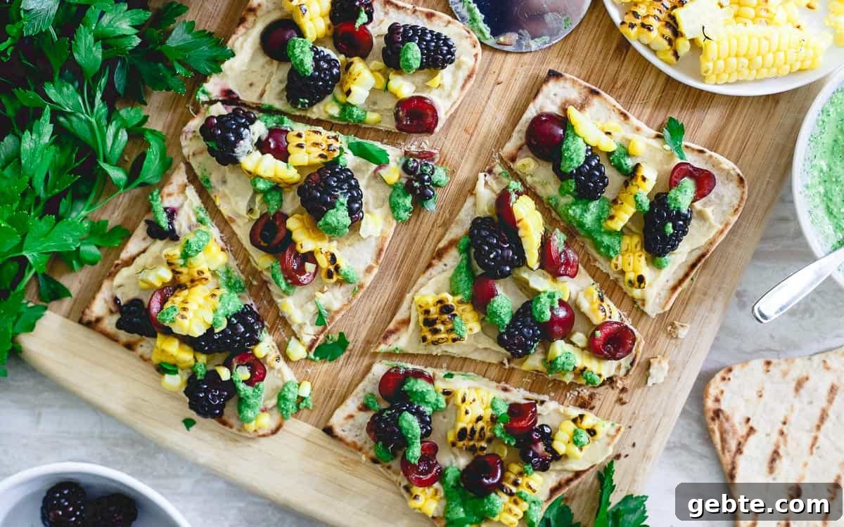 This hummus flatbread is a pre-dinner snack bursting with summer flavors from grilled corn to berries, cherries and fresh parsley pesto. This hummus flatbread is a pre-dinner snack bursting with summer flavors from grilled corn to berries, cherries and fresh parsley pesto.