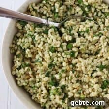Warm Barley Salad with Garden Herbs and Lemon Vinaigrette 5 Barley salad with fresh herbs in a bowl with a spoon