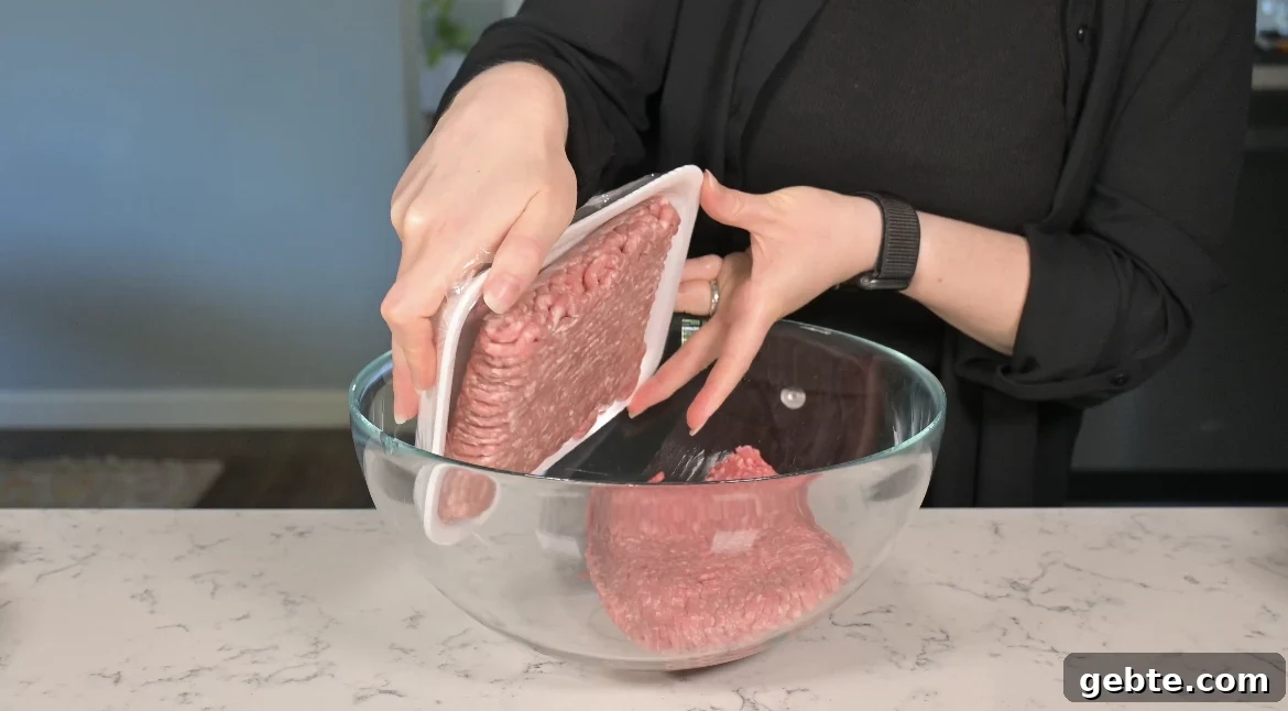 Authentic Swedish Köttbullar Recipe: Classic Meatballs with Creamy Gravy 12 Adding ground meat to a mixing bowl.