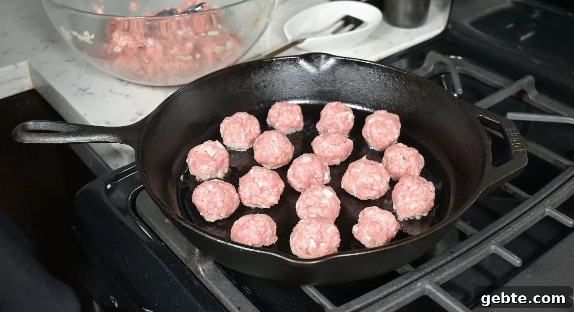 Authentic Swedish Köttbullar Recipe: Classic Meatballs with Creamy Gravy 16 Meatballs cooking in a pan.