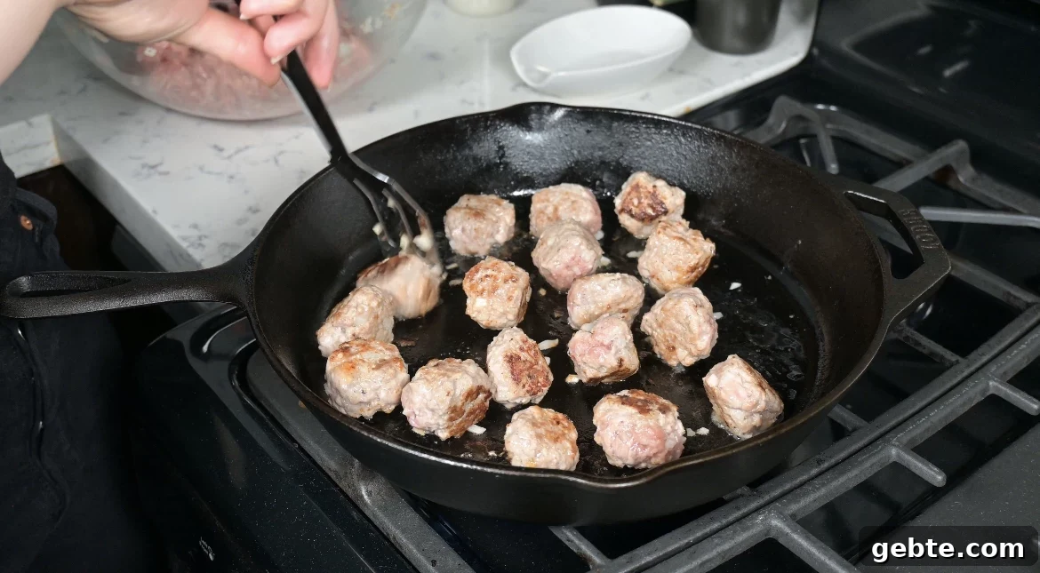 Authentic Swedish Köttbullar Recipe: Classic Meatballs with Creamy Gravy 17 Cooking meatballs in a pan.