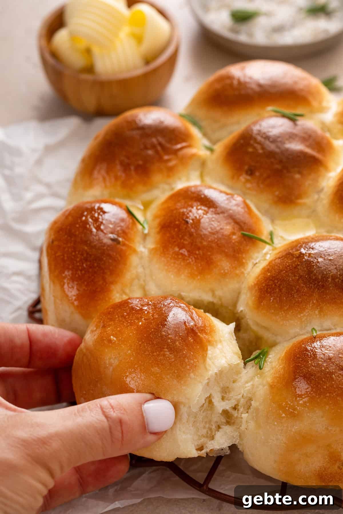 Person taking a roll from baked brown and serve rolls.
