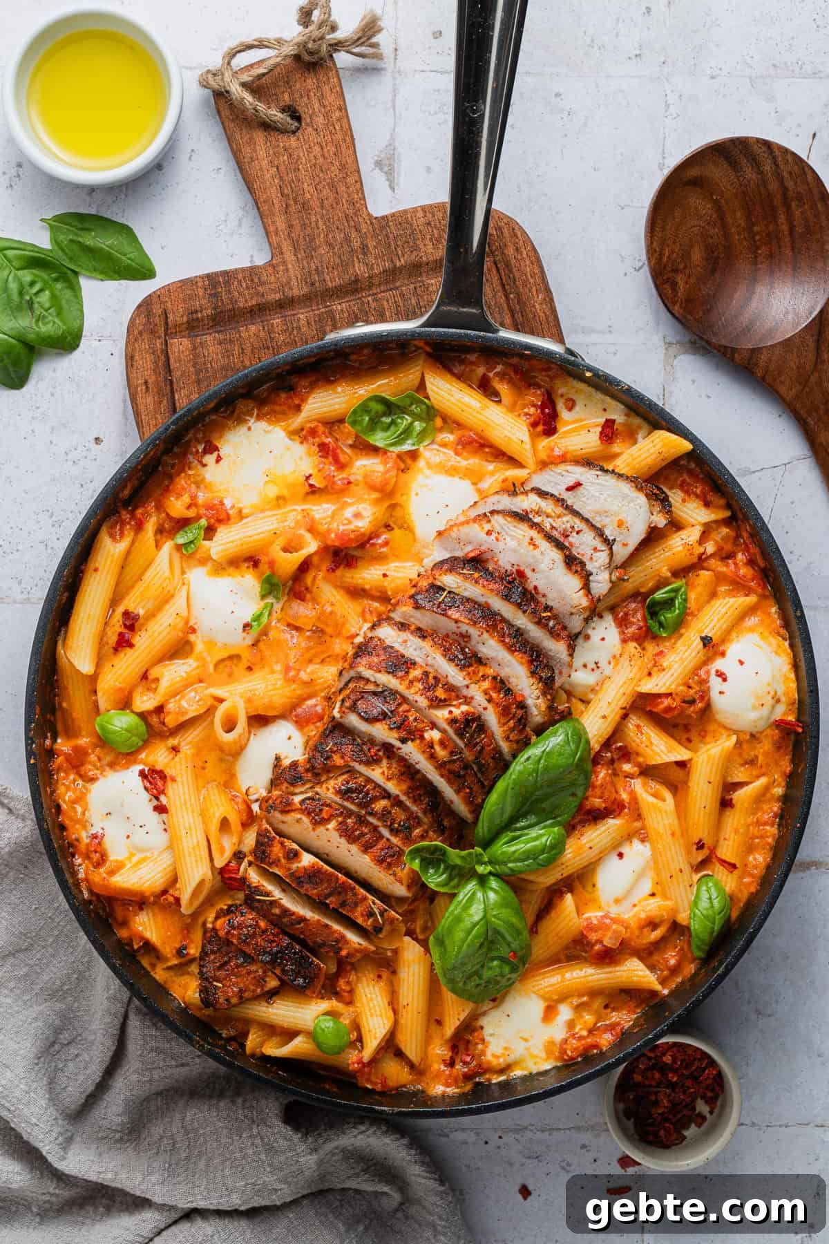 Creamy Vodka Penne with Grilled Chicken and Parmesan 11 The completed dish with sliced chicken on top of the pasta and vodka sauce.