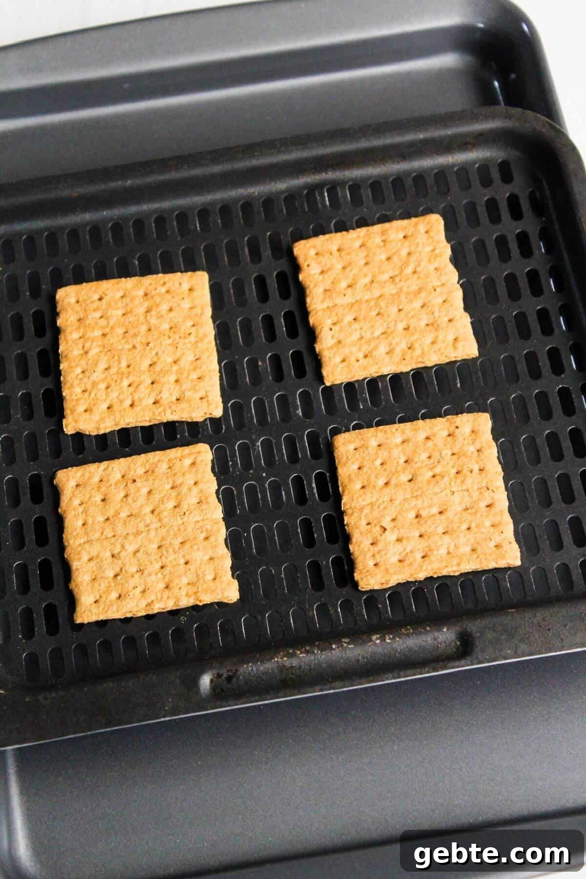Crispy Air Fryer S'mores Recipe: Gooey Campfire Treats Fast 4 Four squares of graham crackers on an air fryer tray.