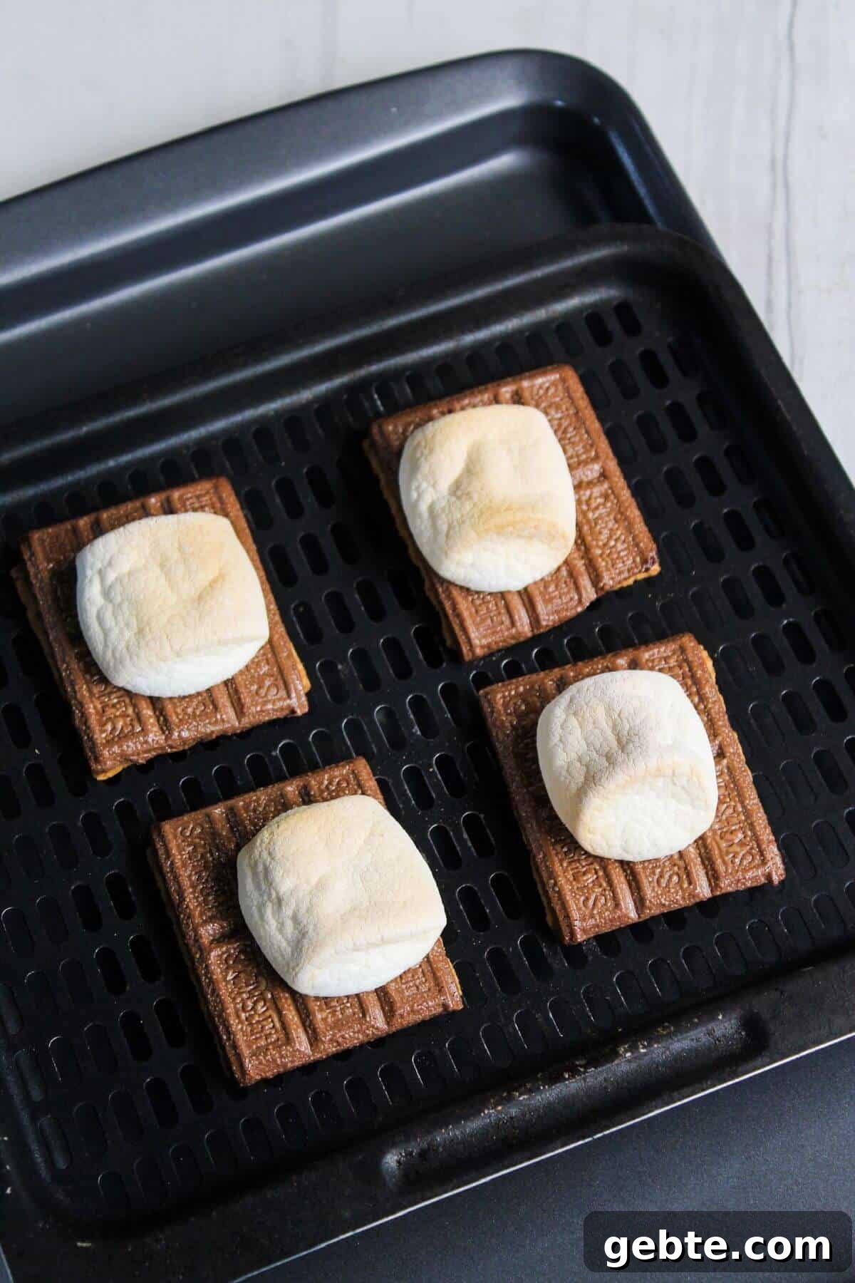 Crispy Air Fryer S'mores Recipe: Gooey Campfire Treats Fast 6 Four s'mores are sitting on an air fryer tray