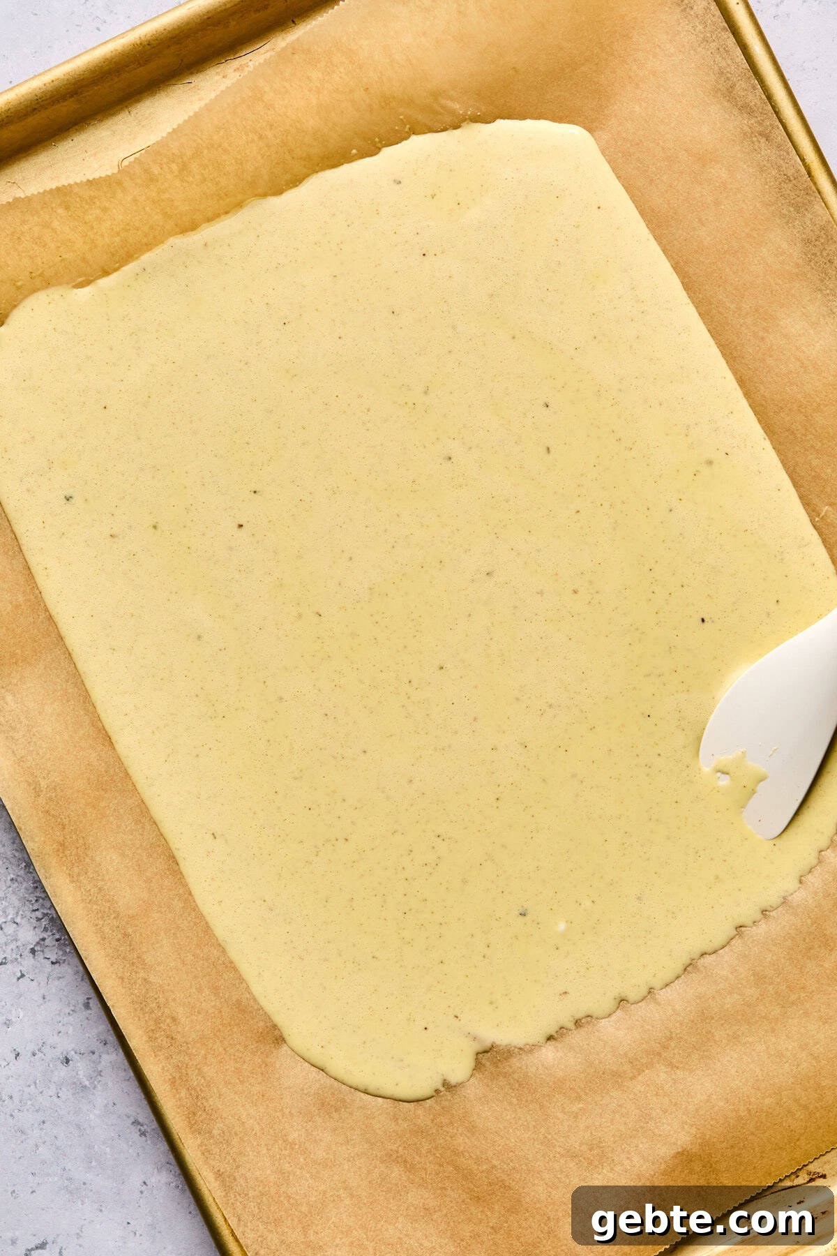 Protein-Packed Cottage Cheese Flatbread (Gluten-Free, Flourless) 6 cottage cheese flatbread liquid ingredients on a parchment lined baking sheet with a white spatula