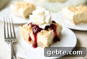 A serving of Rice Krispie Ice Cream Cake topped with berry glaze and Reddi-wip.
