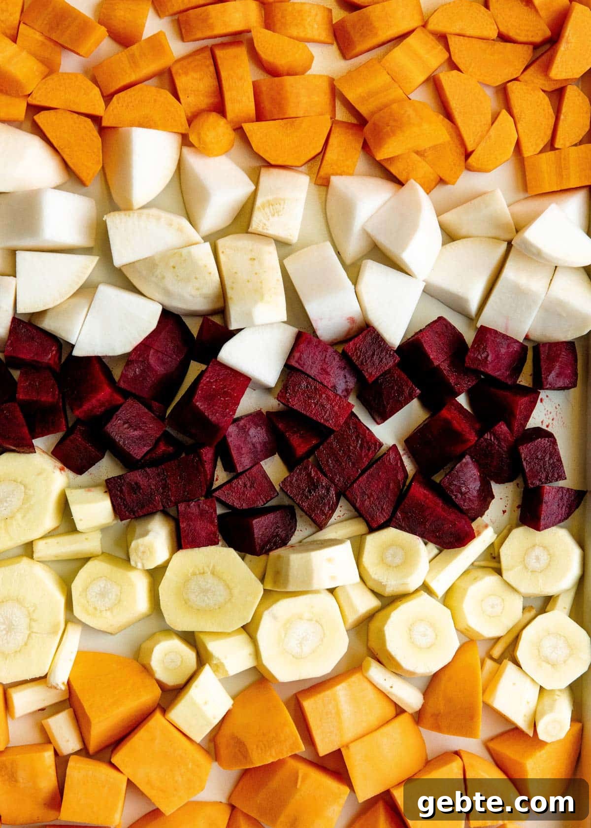 closeup of cubed root vegetables on a nonstick rimmed baking sheet