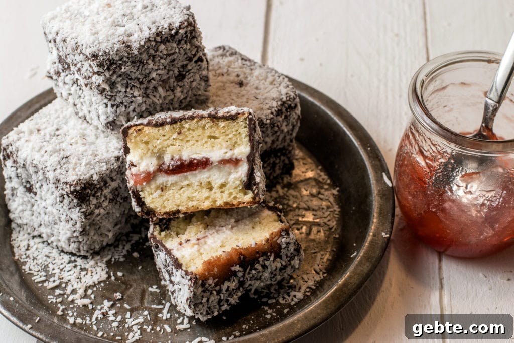 Gluten-free jam filled lamingtons on a rustic pie tin with a jar of strawberry jam.