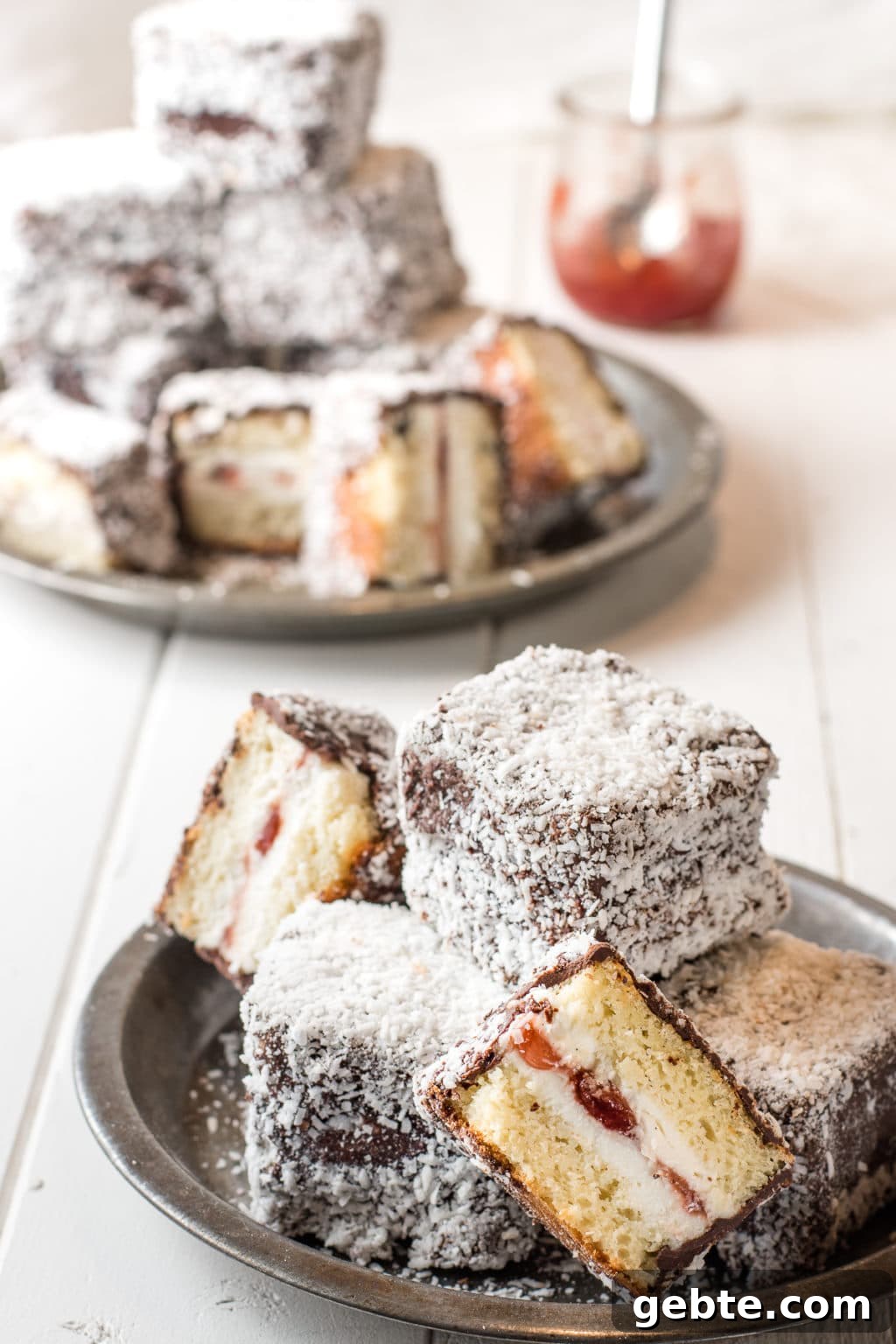 gluten-free lamintons with chocolate and coconut coating stacked on rustic pie tins