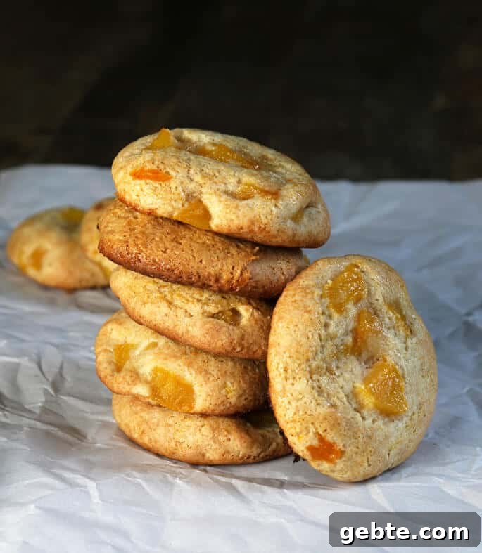 Stack of peach pie cookies on a white surface. 