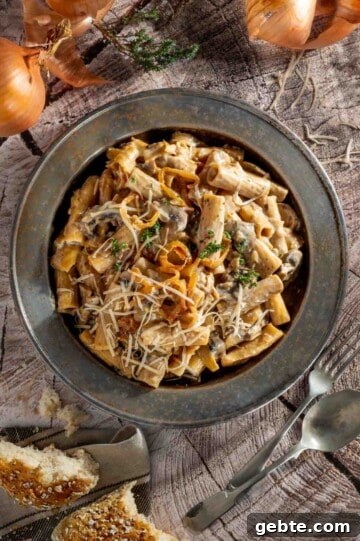 Top Pasta Recipes to Make Tonight 7 A plate of french onion pasta on a wooden background.