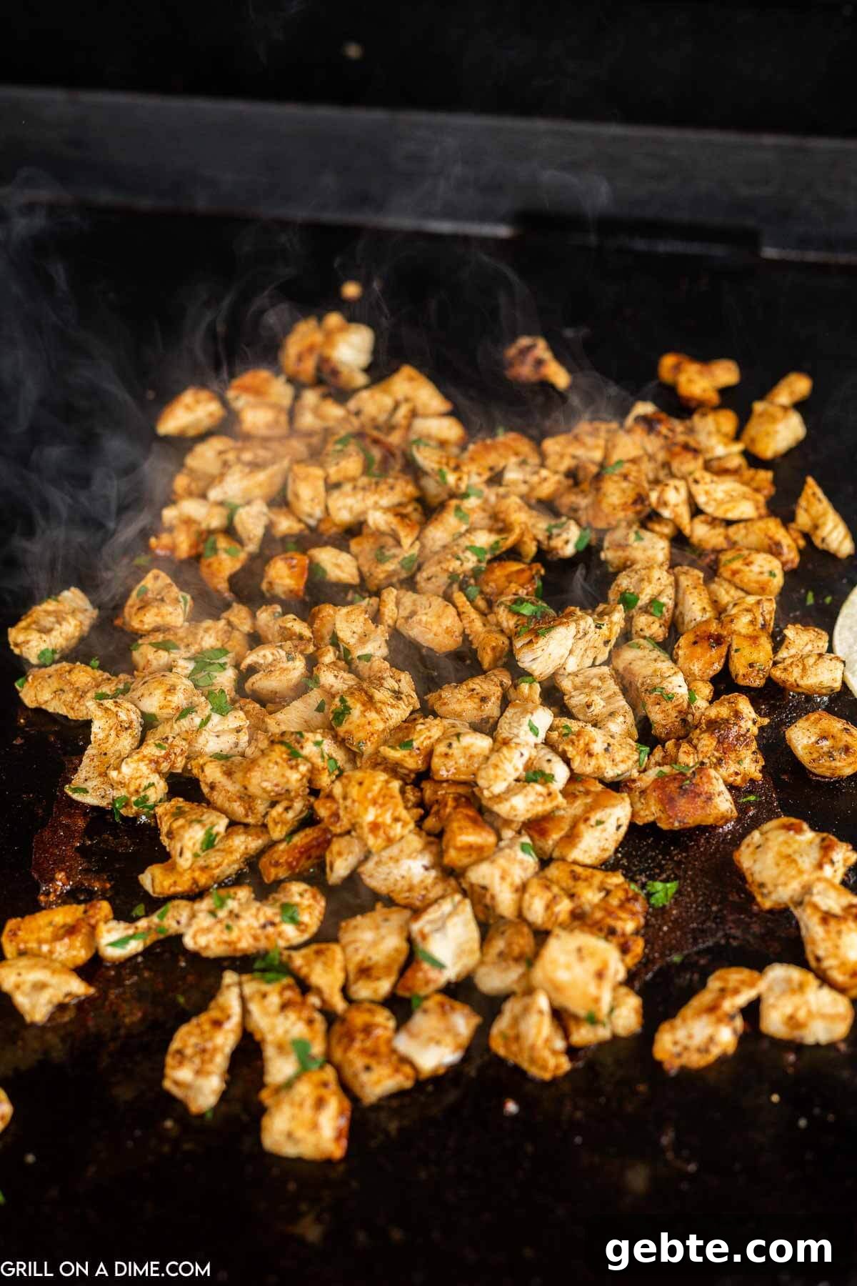 Crispy Blackstone Chicken Tacos with Charred Corn Salsa 4 Cooked Chicken bites on the griddle.