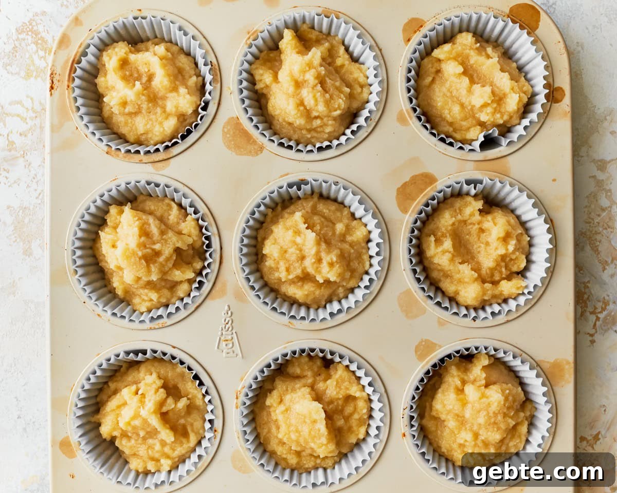 Batter added to a lined muffin pan for coconut flour muffins.