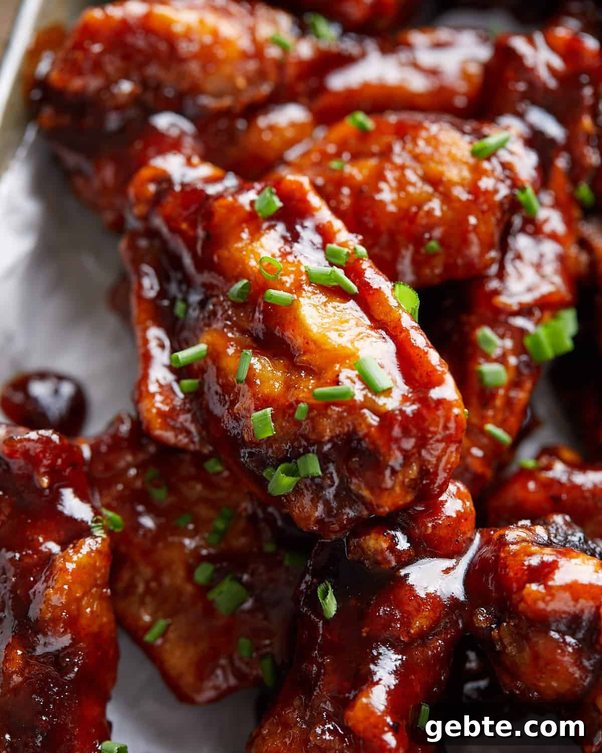 Up close image of sticky bbq chicken wings with garnish.