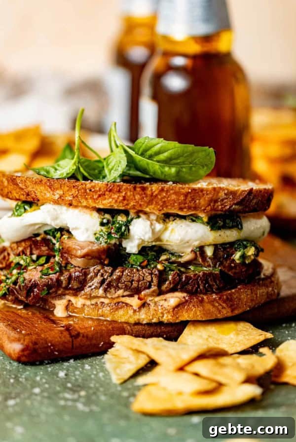 ribeye steak sandwich with chimichurri on a serving board with chips.