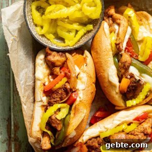 chicken philly cheesesteak sandwich in a tray with banana peppers on top.