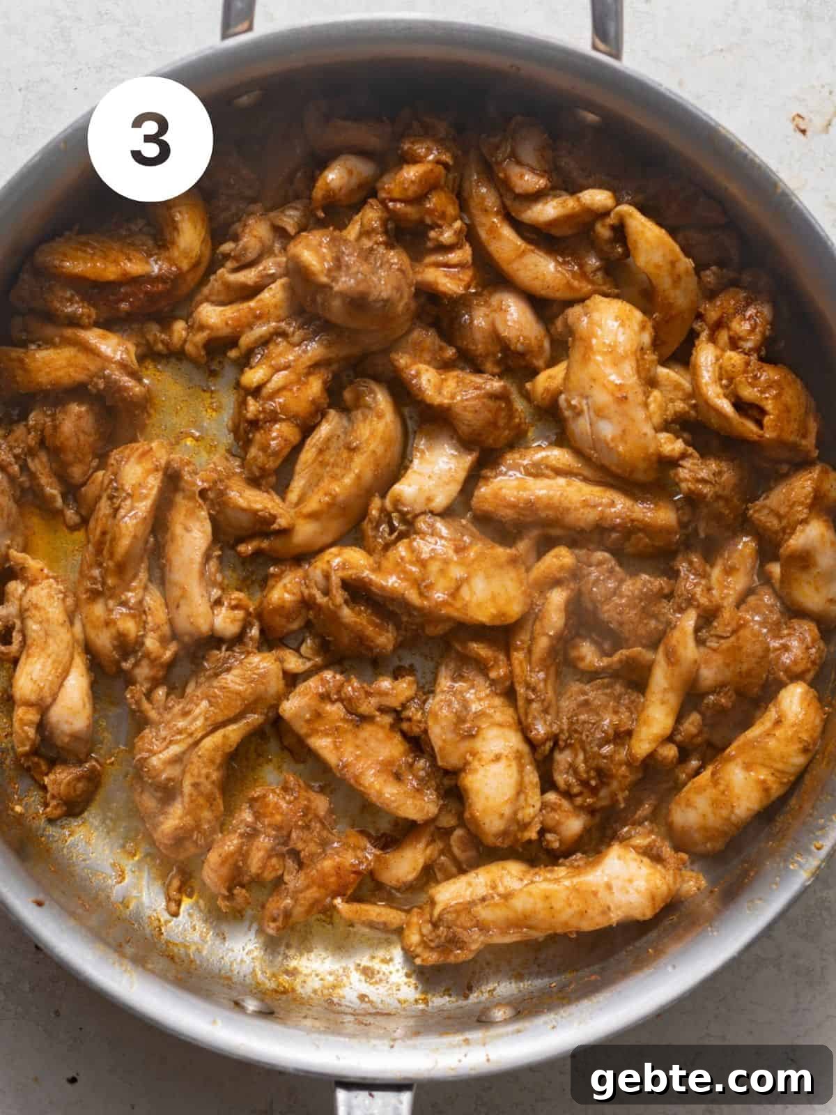 sliced chicken thighs cooked in a skillet.