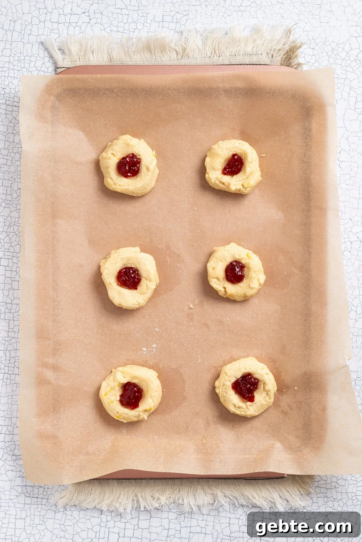 An overhead image of strawberry lemonade cookie dough balls on a baking sheet.