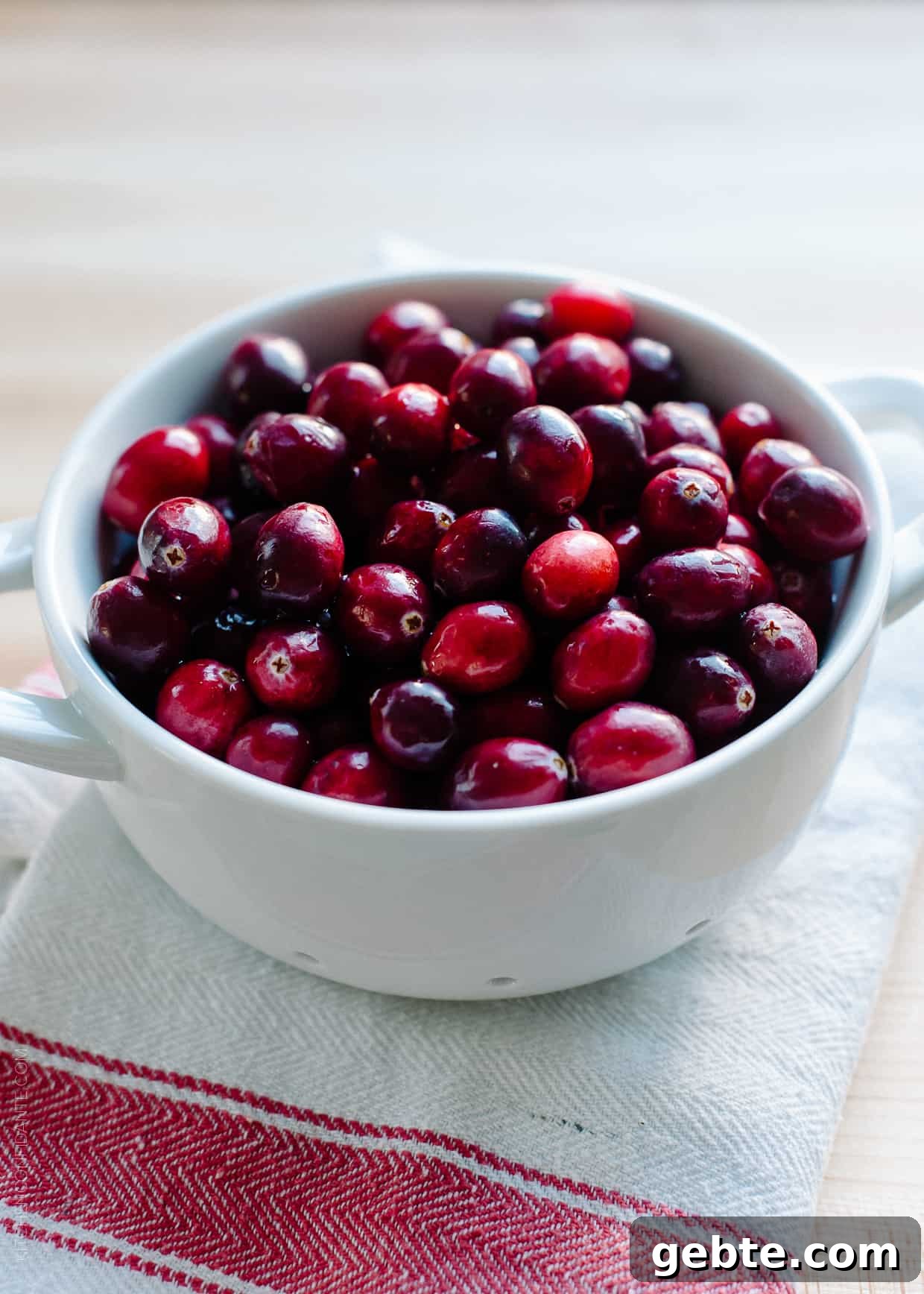 Cranberry Wine Sauce Recipe for Holiday Roasts and Sides 3 Freshly washed fruit in a white ceramic colander.