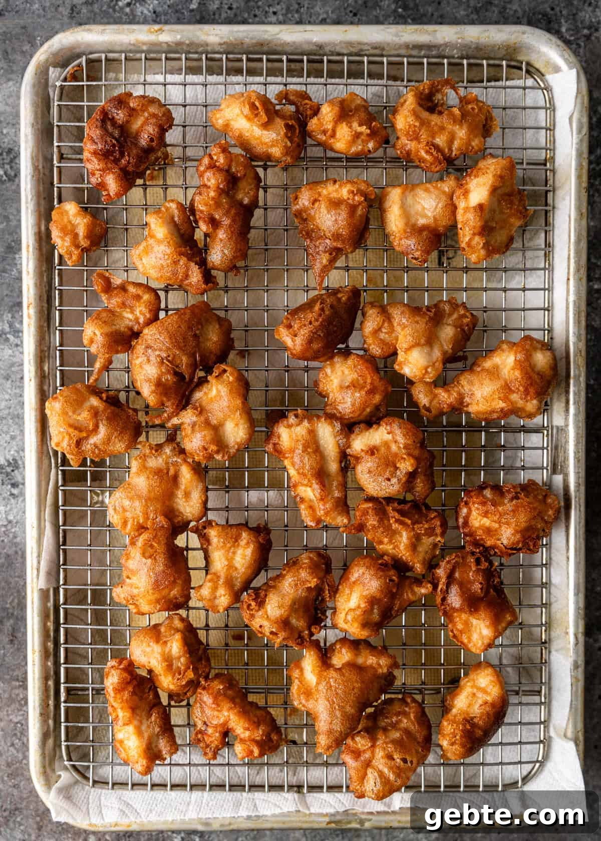 overhead: crispy almond chicken cooling on a wire rack after frying