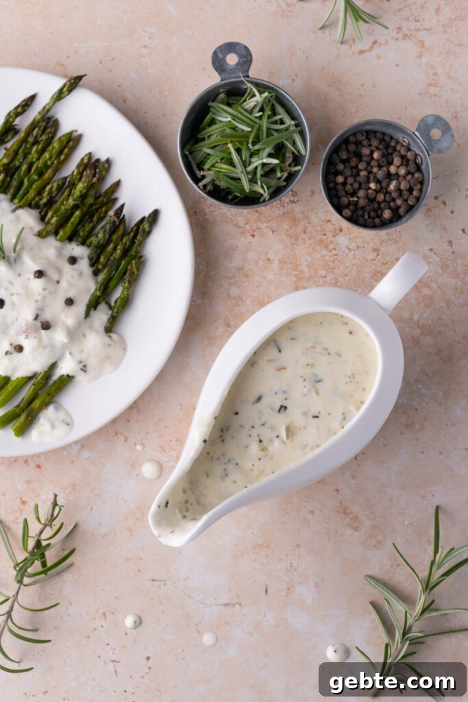 Shallot Cream Sauce in a gravy boat next to sauce-coated asparagus