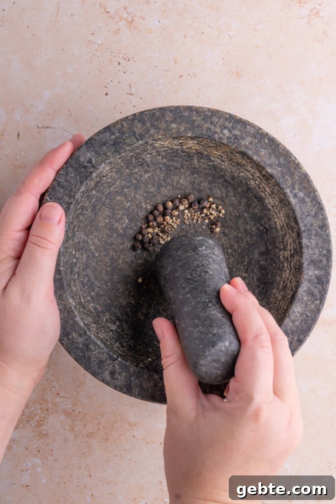 Crushing peppercorn with pestle and mortar