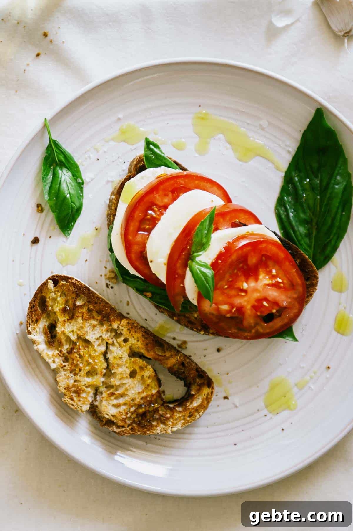 Caprese Bruschetta Recipe: Fresh Tomato, Basil & Mozzarella Toast 2 overhead view of caprese bruschetta with olive oil drizzle.