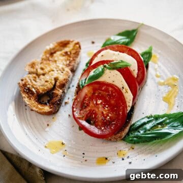 Caprese Bruschetta Recipe: Fresh Tomato, Basil & Mozzarella Toast 12 caprese bruschetta served on a plate with an extra slice of toasted bread.
