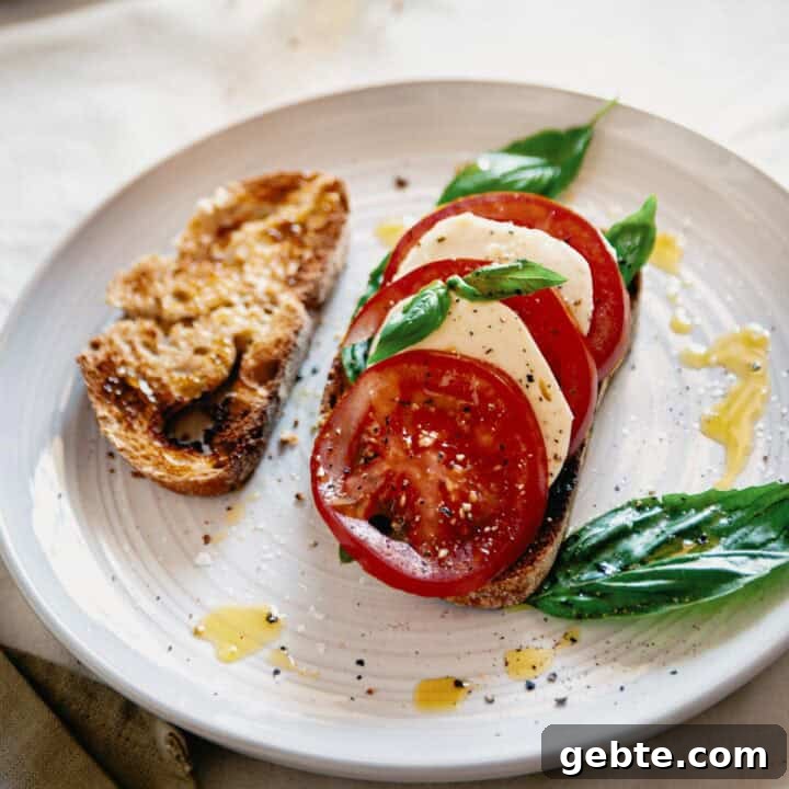 Caprese Bruschetta Recipe: Fresh Tomato, Basil & Mozzarella Toast 3 caprese bruschetta served on a plate with an extra slice of toasted bread.