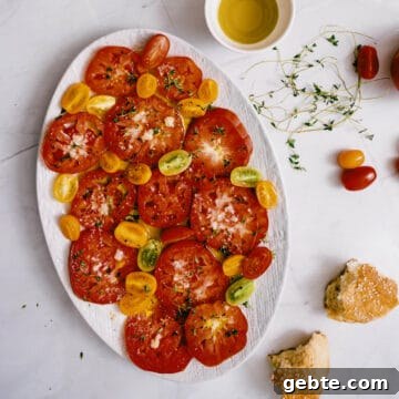 an heirloom tomato salad presented on a large white platter.