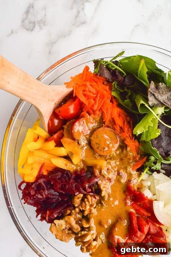 A bowl of vegetables with a golden dressing poured all over on a white marble background