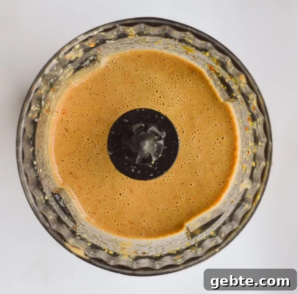 Creamy pale balsamic dressing in a clear dark bowl