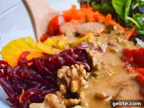 A close-up of a mixed salad with a creamy brown dressing