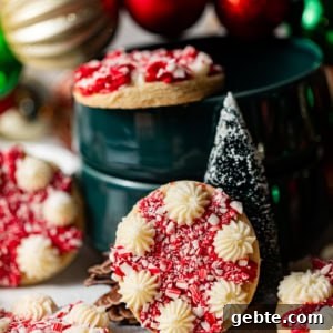 Crunchy Peppermint Chocolate Chip Cookies Recipe 18 peppermint cookies on a white surface decorated with christmas ornaments and mini christmas trees.