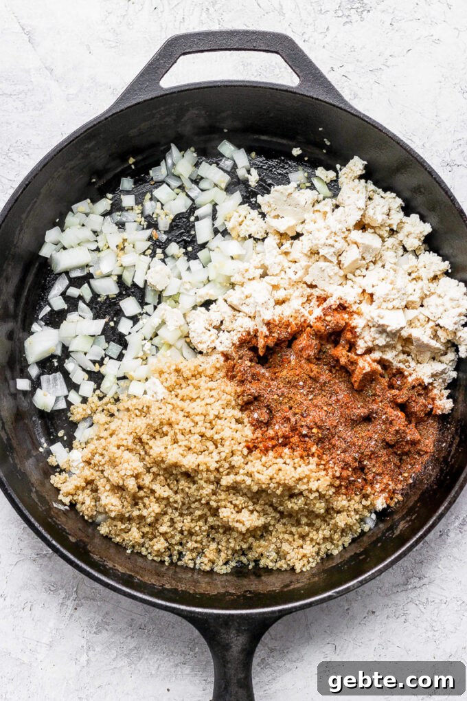 Quinoa and Tofu Taco Filling Recipe for Meatless Tacos 4 tofu taco meat ingredients in a skillet: tofu crumbles, taco seasoning, quinoa and onion