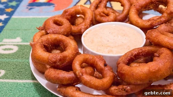 Light and crispy onion rings recipe that are deep fried in a beer batter coating with a cajun dip similar to the kind from Outback Steakhouses Bloomin' Onion.