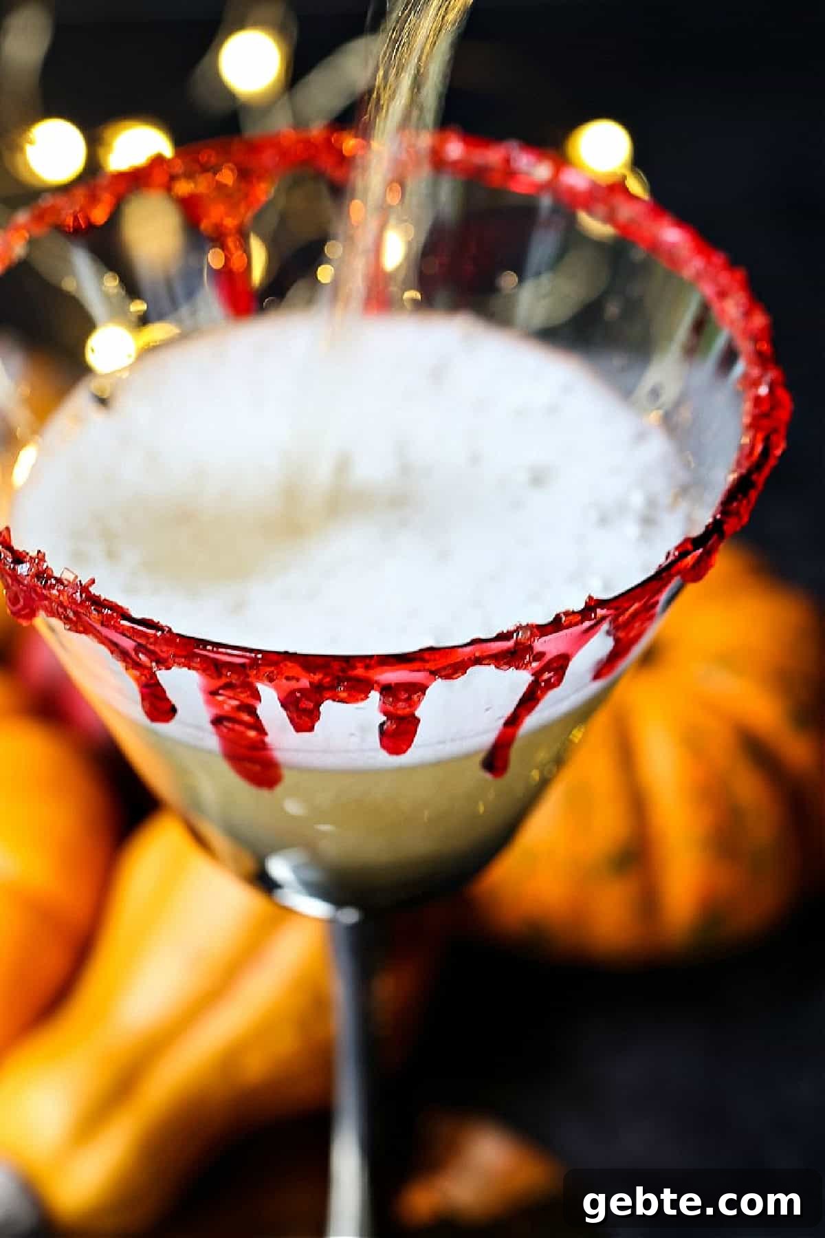 champagne being poured into martini glass with fake blood