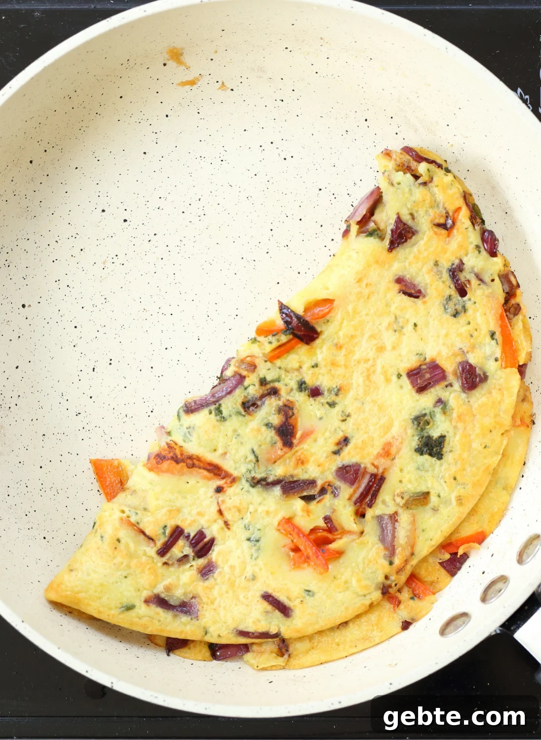 Mung Bean Egg Vegan Omelet: Fluffy Plant-Based Breakfast 3 Veggie Vegan Omelet on a white skillet