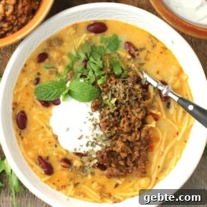 Aush soup thumbnail, top-down view of bowl of aush, topped with yogurt sauce and meat.