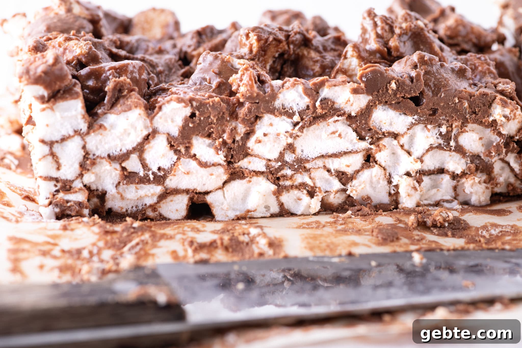 A centre slice of chocolate covered marshmallow bars on parchment 