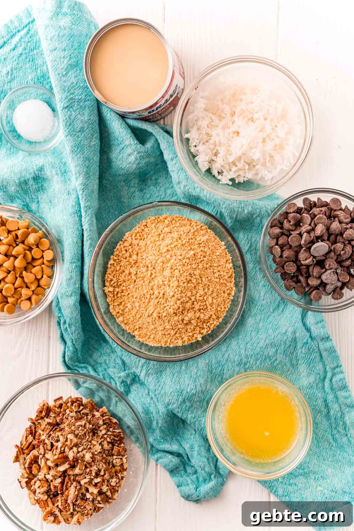 Classic Hello Dolly 7-Layer Cookie Bars Recipe 4 Ingredients to make hello dolly or seven layer bars on a white table with a blue napkin.