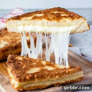 Crispy Mozzarella in Carrozza Sandwiches: Classic Italian Fried Cheese 9 fried cheese sandwich cut in half and showing cheese pull.