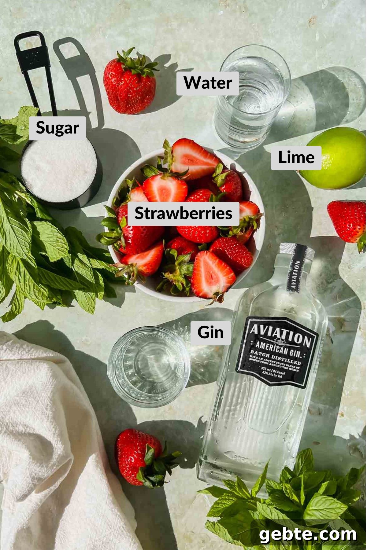 Strawberry Gin Smash: Refreshing Cocktail Recipe for Summer 3 labeled strawberry gin smash ingredients in individual bowls and glasses.